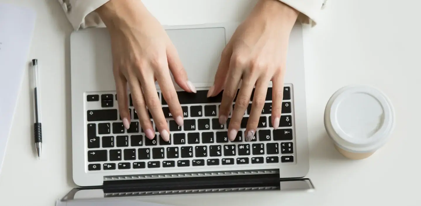businesswoman-working-laptop-hands-typing-keyboard-top-view 1